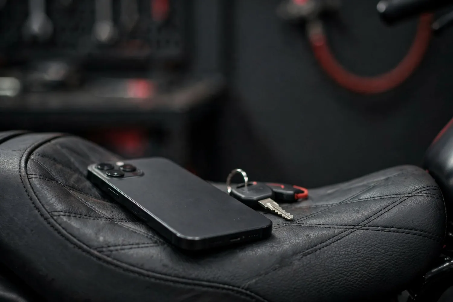 A phone and a key on a motorcycle seat